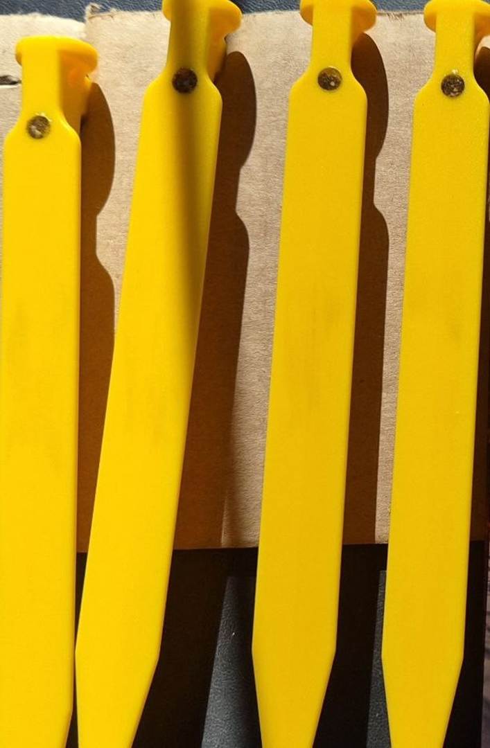 The image shows four bright yellow plastic knives neatly arranged in a row.
AI-generated content may be incorrect.